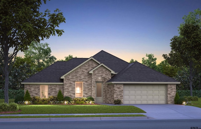 view of front of house featuring a garage and a yard