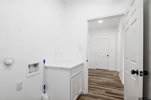 clothes washing area with wood-type flooring and hookup for a washing machine