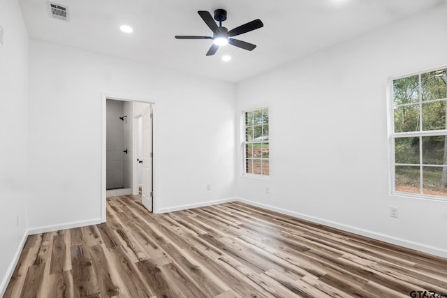 empty room featuring ceiling fan, plenty of natural light, and light hardwood / wood-style flooring