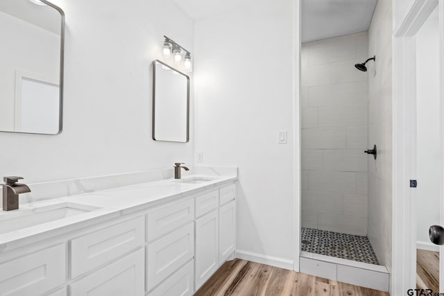 bathroom featuring tiled shower, vanity, and hardwood / wood-style flooring