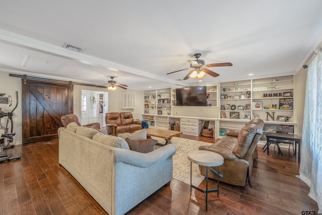 living room with built in shelves, ceiling fan, crown molding, a barn door, and dark hardwood / wood-style flooring