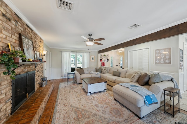 living room with a brick fireplace, ceiling fan, and crown molding