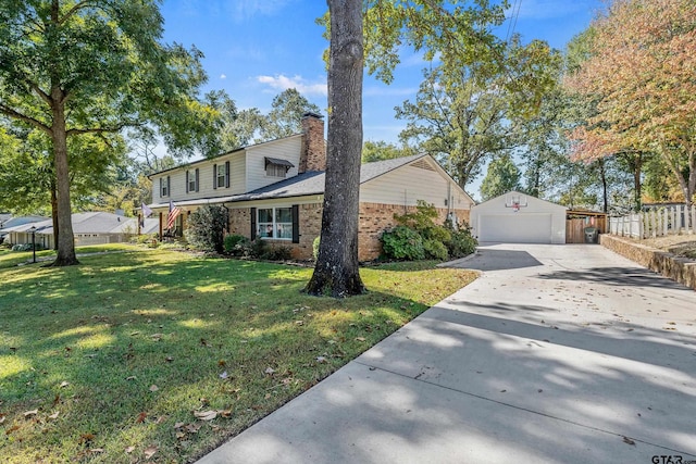 view of property featuring a garage, an outdoor structure, and a front lawn