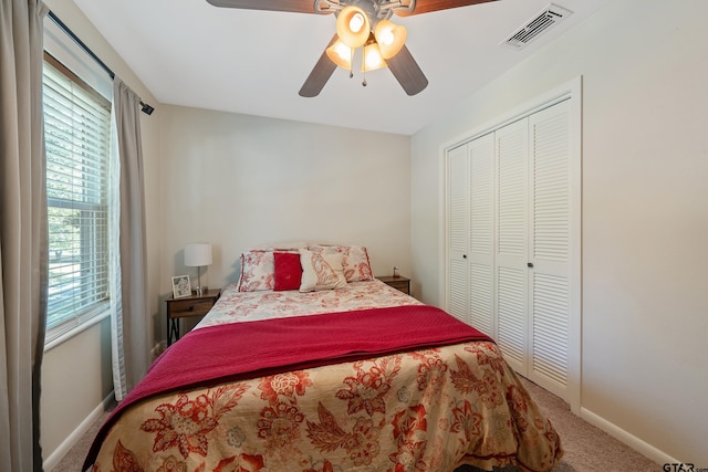 carpeted bedroom with ceiling fan and a closet