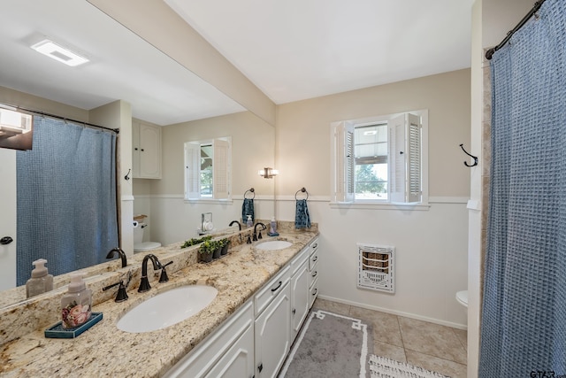 bathroom with toilet, vanity, heating unit, and tile patterned floors