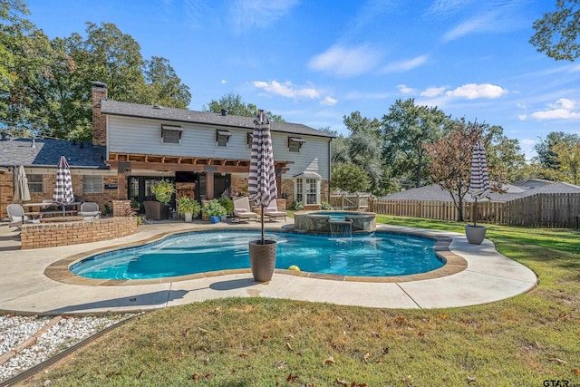 view of pool featuring a patio area, a yard, pool water feature, and an in ground hot tub