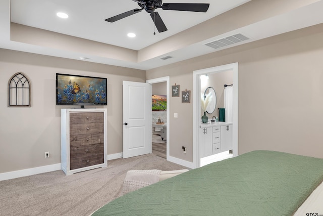 bedroom featuring carpet flooring, ensuite bath, ceiling fan, and a raised ceiling