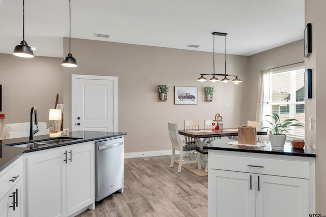 kitchen with stainless steel dishwasher, pendant lighting, sink, white cabinetry, and light hardwood / wood-style floors