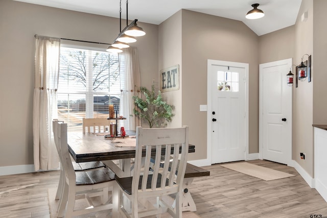 dining area featuring light hardwood / wood-style floors and lofted ceiling