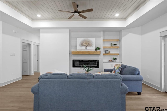 living room featuring ceiling fan, light hardwood / wood-style floors, a raised ceiling, and wooden ceiling