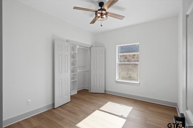 unfurnished bedroom featuring ceiling fan, light hardwood / wood-style floors, and a closet