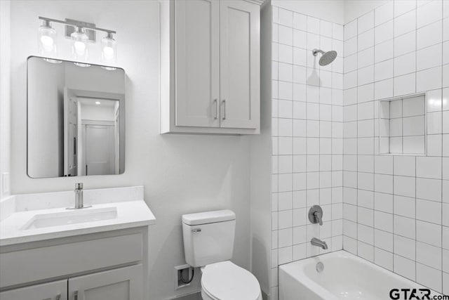 full bathroom featuring toilet, vanity, and tiled shower / bath