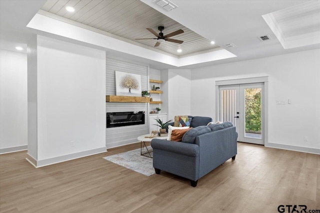 living room with a raised ceiling, ceiling fan, wood ceiling, and light hardwood / wood-style floors