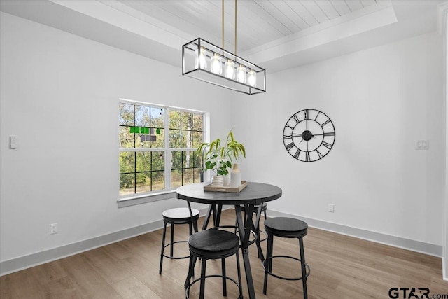 dining room with wood-type flooring, a tray ceiling, and wood ceiling