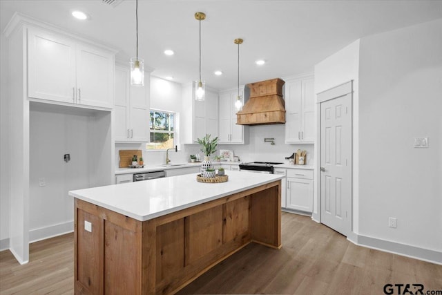 kitchen featuring a kitchen island, white cabinets, light hardwood / wood-style flooring, and custom exhaust hood