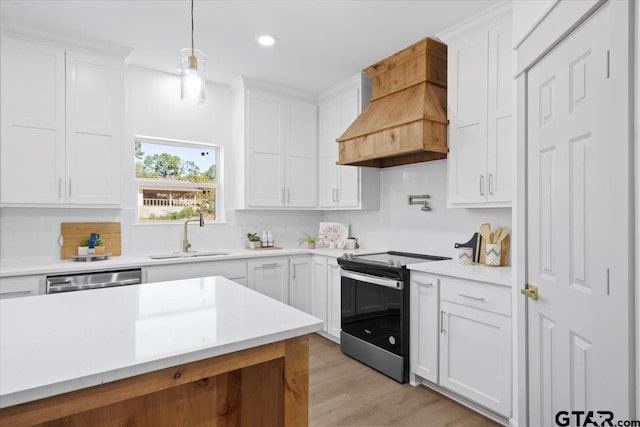 kitchen with white cabinets, custom exhaust hood, sink, and black / electric stove