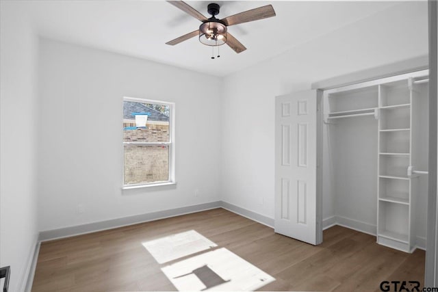 unfurnished bedroom featuring ceiling fan, a closet, and light wood-type flooring