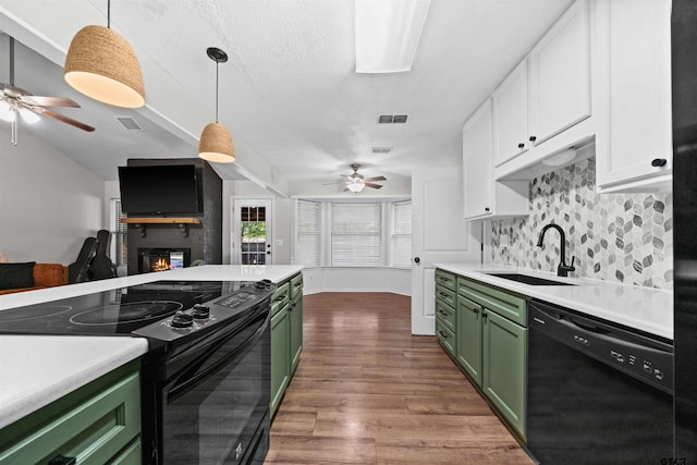 kitchen featuring white cabinets, green cabinetry, sink, and black appliances