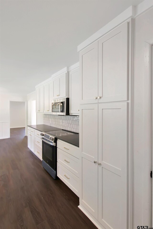 1301 Roseland Blvd, Tyler, TX 75701 - kitchen with stainless steel appliances, dark wood finished floors, white cabinets, and tasteful backsplash