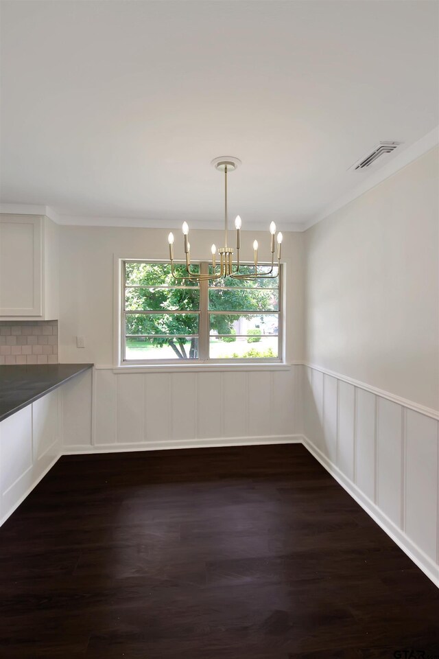 1301 Roseland Blvd, Tyler, TX 75701 - unfurnished dining area featuring a chandelier, healthy amount of natural light, a wainscoted wall, ornamental molding, and dark wood-type flooring