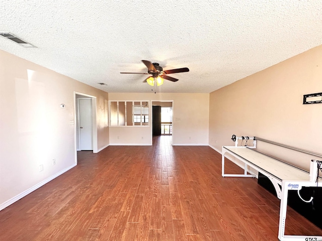 unfurnished room featuring a textured ceiling, wood-type flooring, and ceiling fan