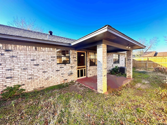 rear view of property with cooling unit and a patio