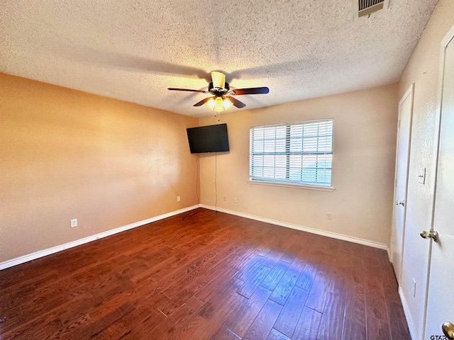 unfurnished bedroom featuring dark hardwood / wood-style flooring, a textured ceiling, and ceiling fan