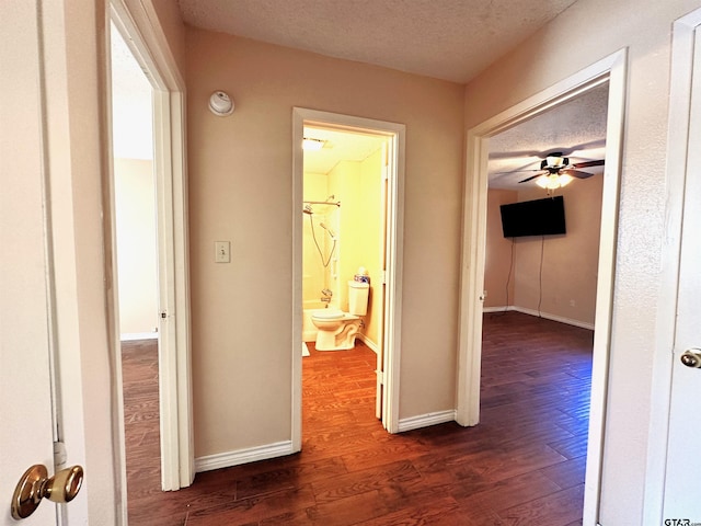 hall with dark wood-type flooring and a textured ceiling