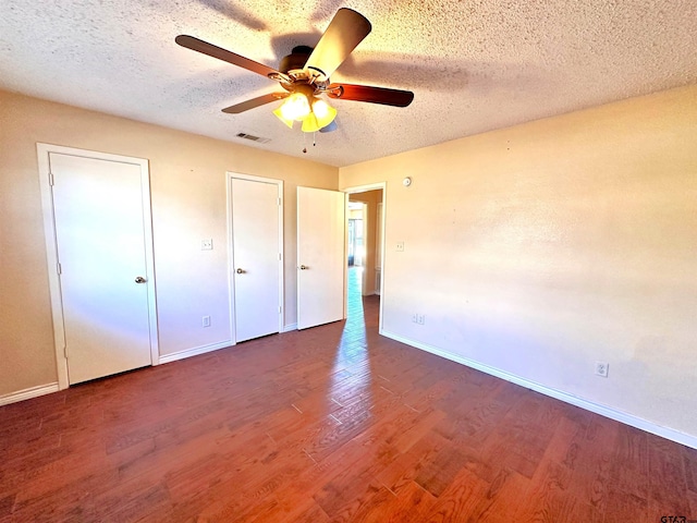 unfurnished bedroom featuring ceiling fan, a textured ceiling, and dark hardwood / wood-style flooring