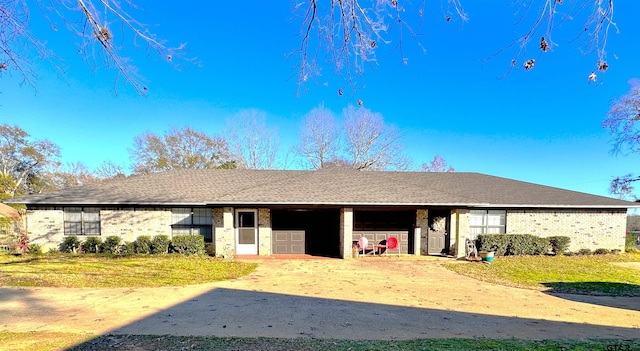 ranch-style home featuring a garage and a front lawn