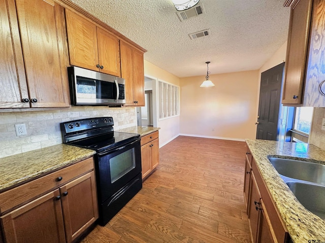 kitchen featuring light hardwood / wood-style floors, backsplash, electric range, and light stone countertops