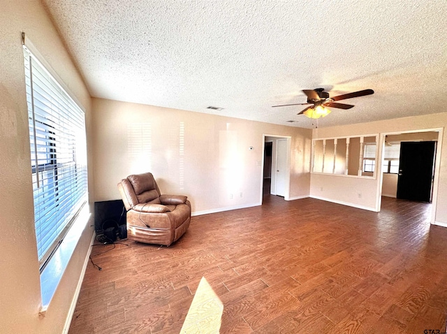 sitting room featuring hardwood / wood-style floors, ceiling fan, and a textured ceiling