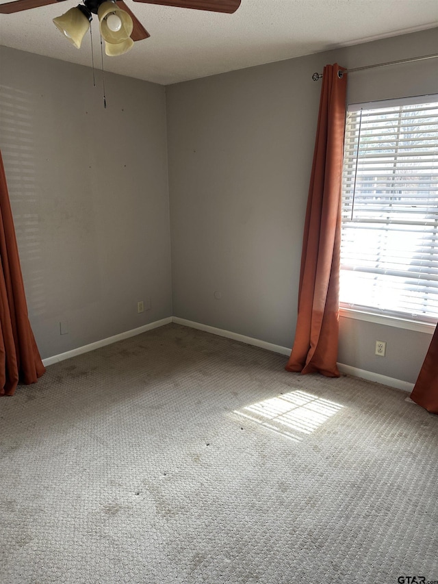 unfurnished room featuring light carpet, plenty of natural light, and baseboards