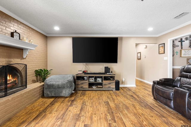 2207 Pinecrest Dr, Gladewater, TX 75647 - living area featuring a textured ceiling, wood finished floors, ornamental molding, and visible vents
