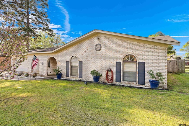 2207 Pinecrest Dr, Gladewater, TX 75647 - view of front of home with a front yard, fence, and brick siding