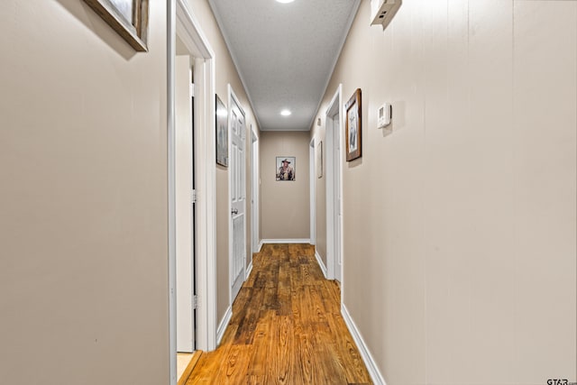 2207 Pinecrest Dr, Gladewater, TX 75647 - hallway featuring a textured ceiling, wood finished floors, and baseboards
