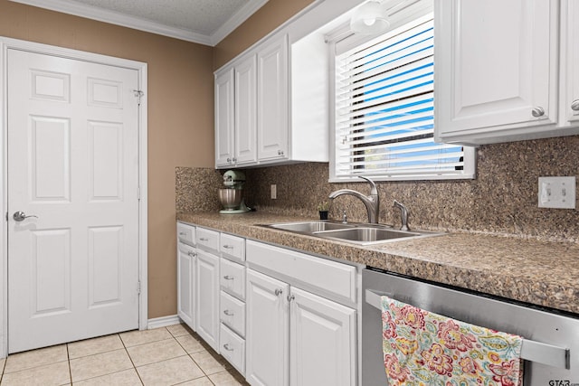 2207 Pinecrest Dr, Gladewater, TX 75647 - kitchen featuring crown molding, light tile patterned flooring, white cabinets, stainless steel dishwasher, and a sink