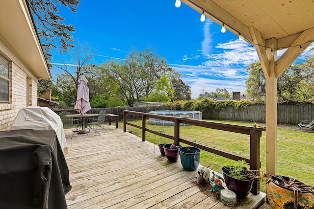 2207 Pinecrest Dr, Gladewater, TX 75647 - wooden deck with a fenced backyard, outdoor dining space, area for grilling, and a lawn