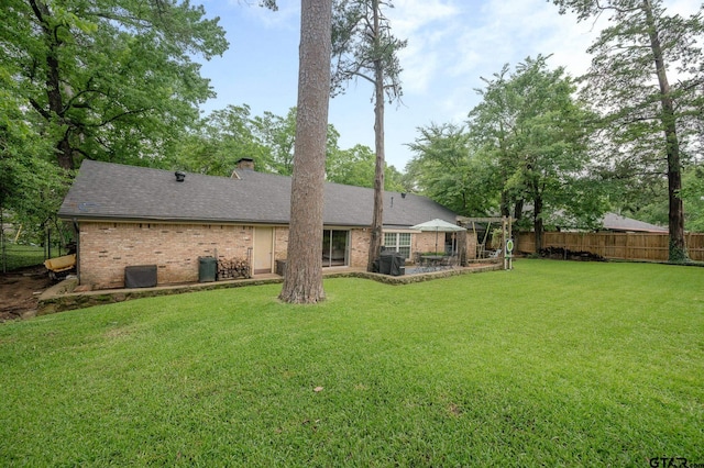 1018 Pollard Dr, Tyler, TX 75701 - back of property featuring brick siding, a chimney, and roof with shingles