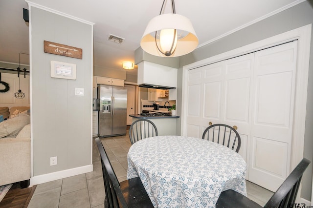 1018 Pollard Dr, Tyler, TX 75701 - dining area featuring crown molding, light tile patterned floors, and baseboards