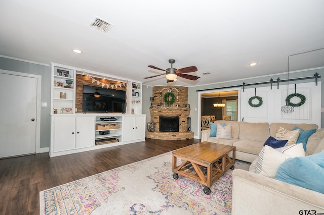1018 Pollard Dr, Tyler, TX 75701 - living room featuring ceiling fan, ornamental molding, a fireplace, wood finished floors, and a barn door