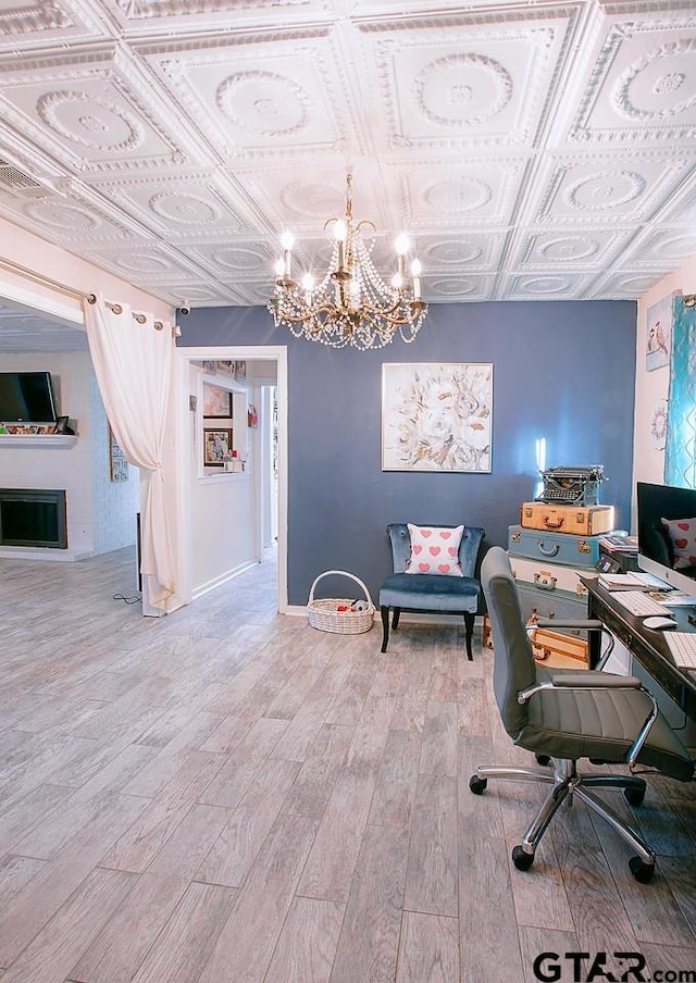 home office featuring wood-type flooring and an inviting chandelier