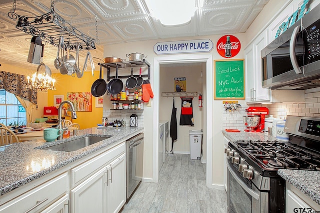 kitchen featuring white cabinetry, sink, light hardwood / wood-style floors, and appliances with stainless steel finishes