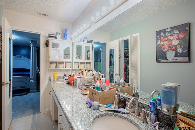 bathroom featuring tile patterned floors, vanity, and a textured ceiling