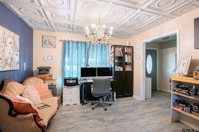 home office with a notable chandelier and light hardwood / wood-style floors