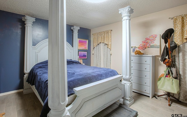 bedroom with light hardwood / wood-style floors and a textured ceiling