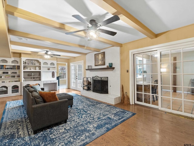 2808 Tryon Rd, Longview, TX 75605 - living room with french doors, hardwood / wood-style flooring, beamed ceiling, ceiling fan, and a fireplace
