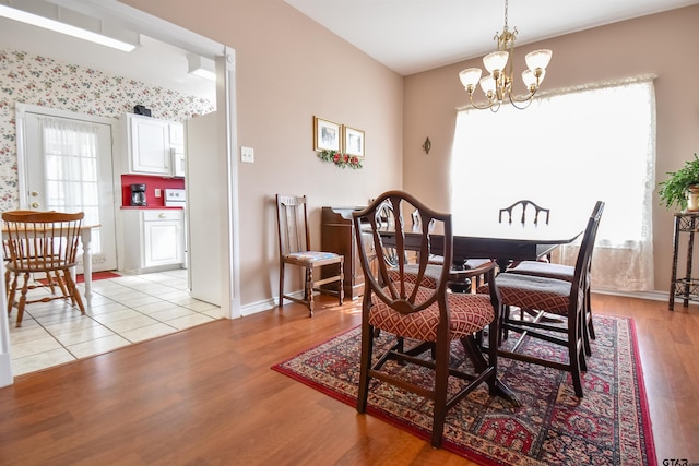 dining area featuring light wood-type flooring and an inviting chandelier