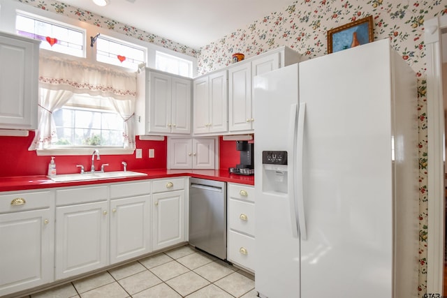 kitchen featuring dishwasher, white cabinetry, sink, white fridge with ice dispenser, and light tile patterned floors