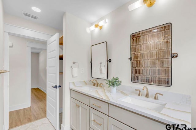 8100 Jewell Ln, Tyler, TX 75703 - bathroom with double vanity, marble look tile flooring, and baseboards